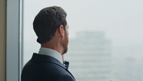 disappointed businessman talking phone emotionally standing in office close up.