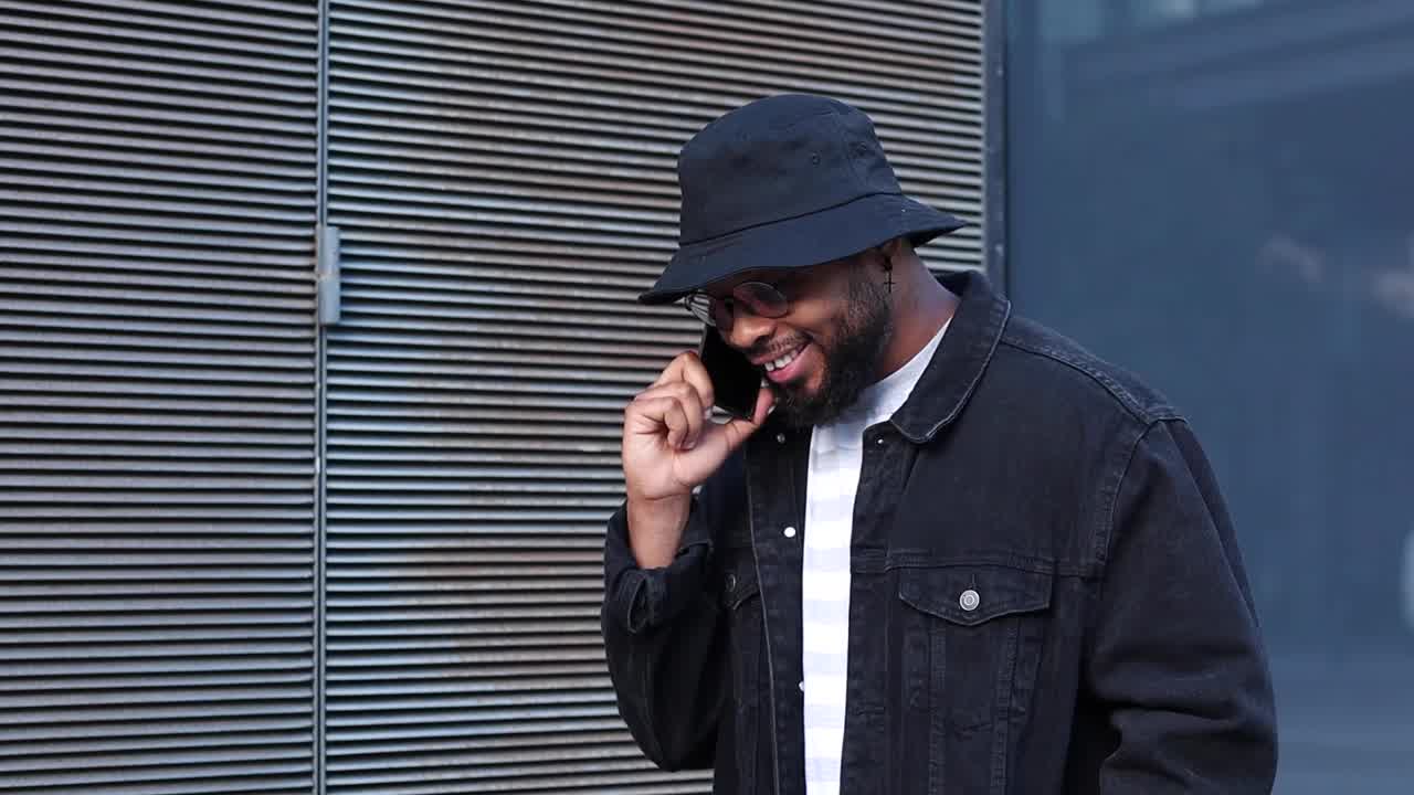 Laughing black man talking smartphone