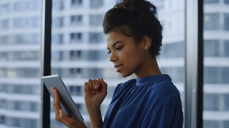 Geschäftsfrau nutzt Digital-Tablet in der Lobby. Weibliche Fachkraft arbeitet am Tablet.
