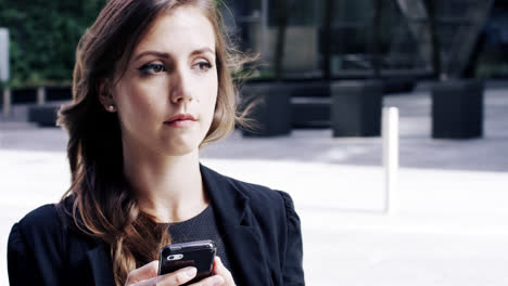 attractive business woman commuter using smartphone in city of london