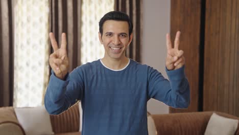 proud indian man showing victory sign