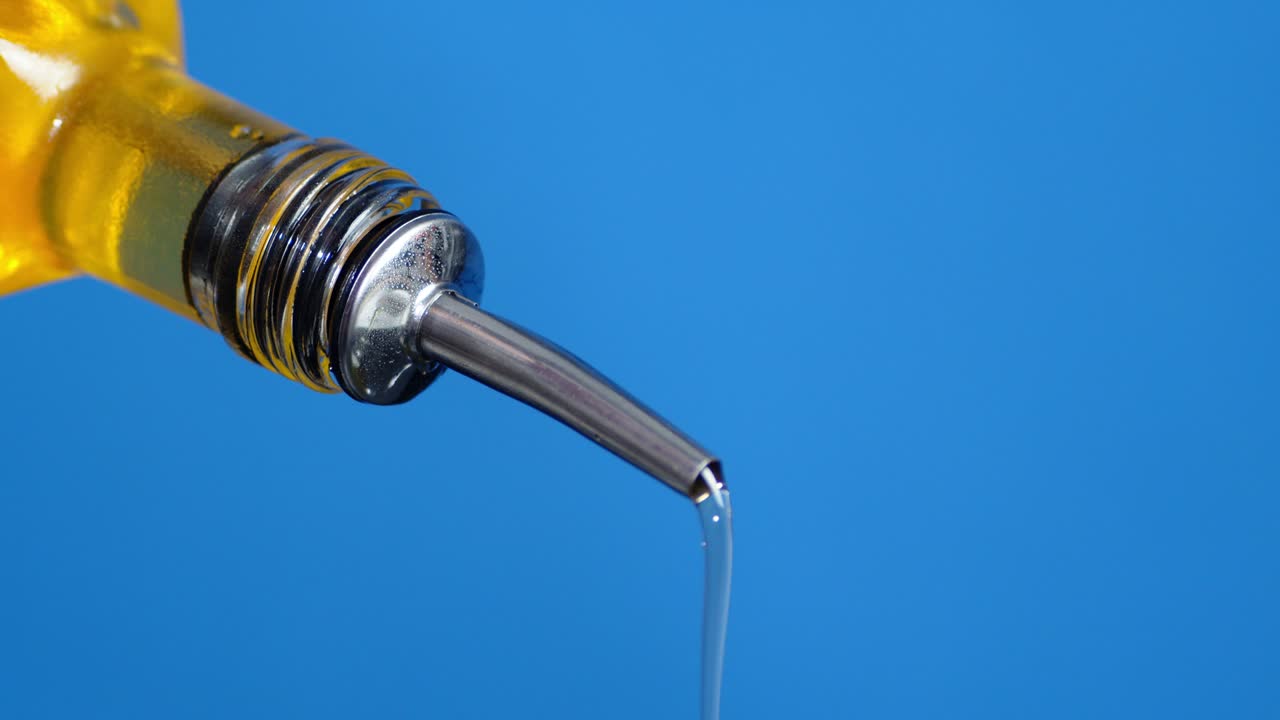 de la botella vierte una corriente de aceite de oliva.