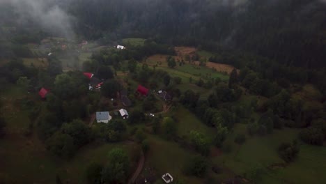 Drone-camera-filming-down-on-romanian-mountain-village-and-panning-to-the-right,-in-Matisesti,-Romania