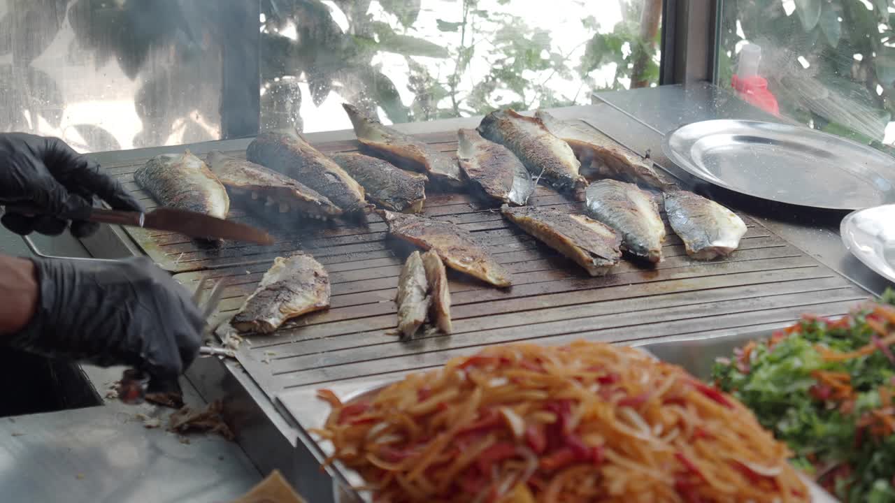 길거리 음식 그릴 에서 물고기 를 는 사람