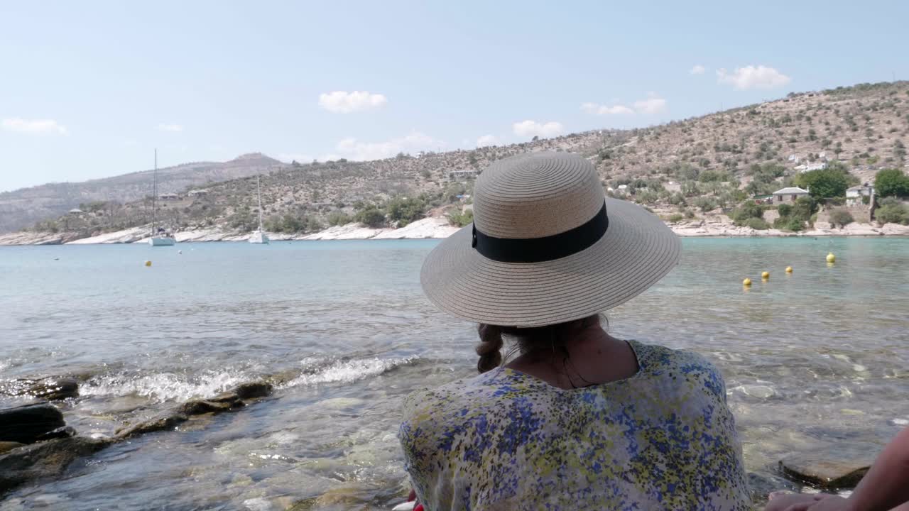 한 소녀가 그리스 타소스 에 있는 알리키 해변  에서 아름다운 에게 해 의 바물 을 즐기고 있다