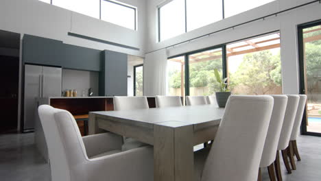 interior of bright open plan dining room and kitchen with doors to garden, copy space, slow motion