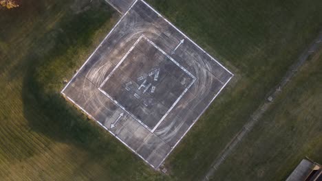 slowly circling aerial view of an empty heliport in a grassy field