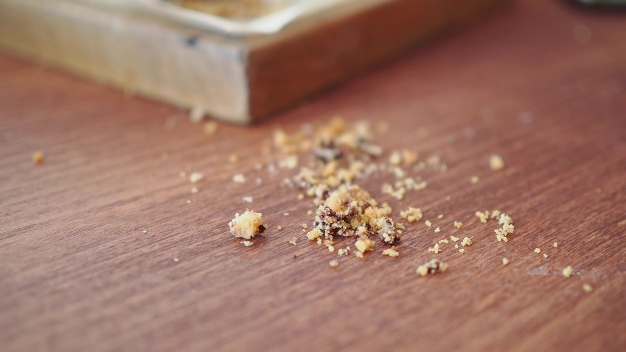 Small Pile of Cookie Crumbs on a Wooden Table