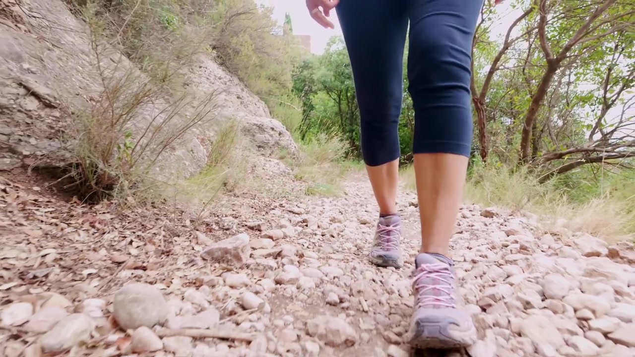 Mujer haciendo senderismo en un sendero rocoso de montaña en Montserrat