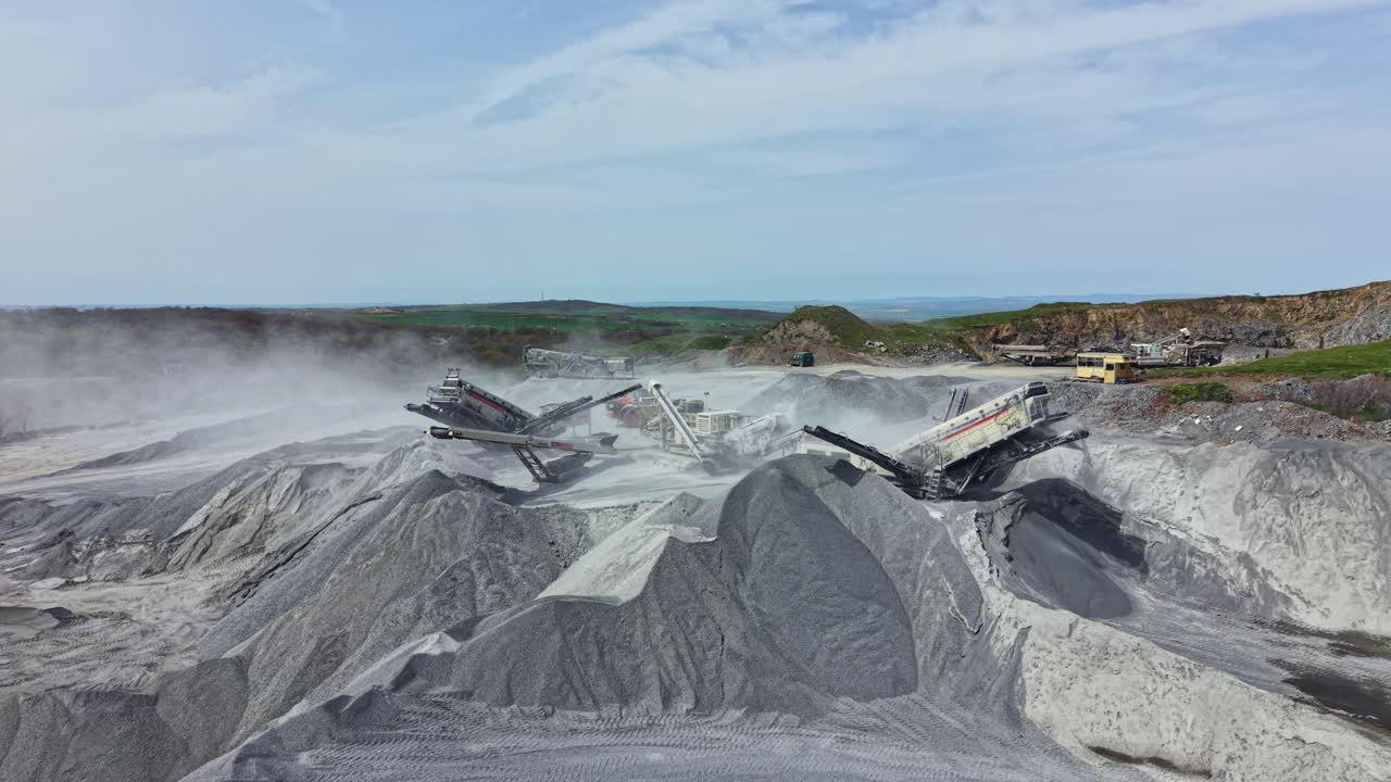 Granite quarry site with machinery working and piles of stone in clear weather