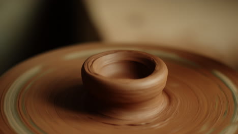 wet clay spinning on potters wheel. unknown woman sculpting product in pottery