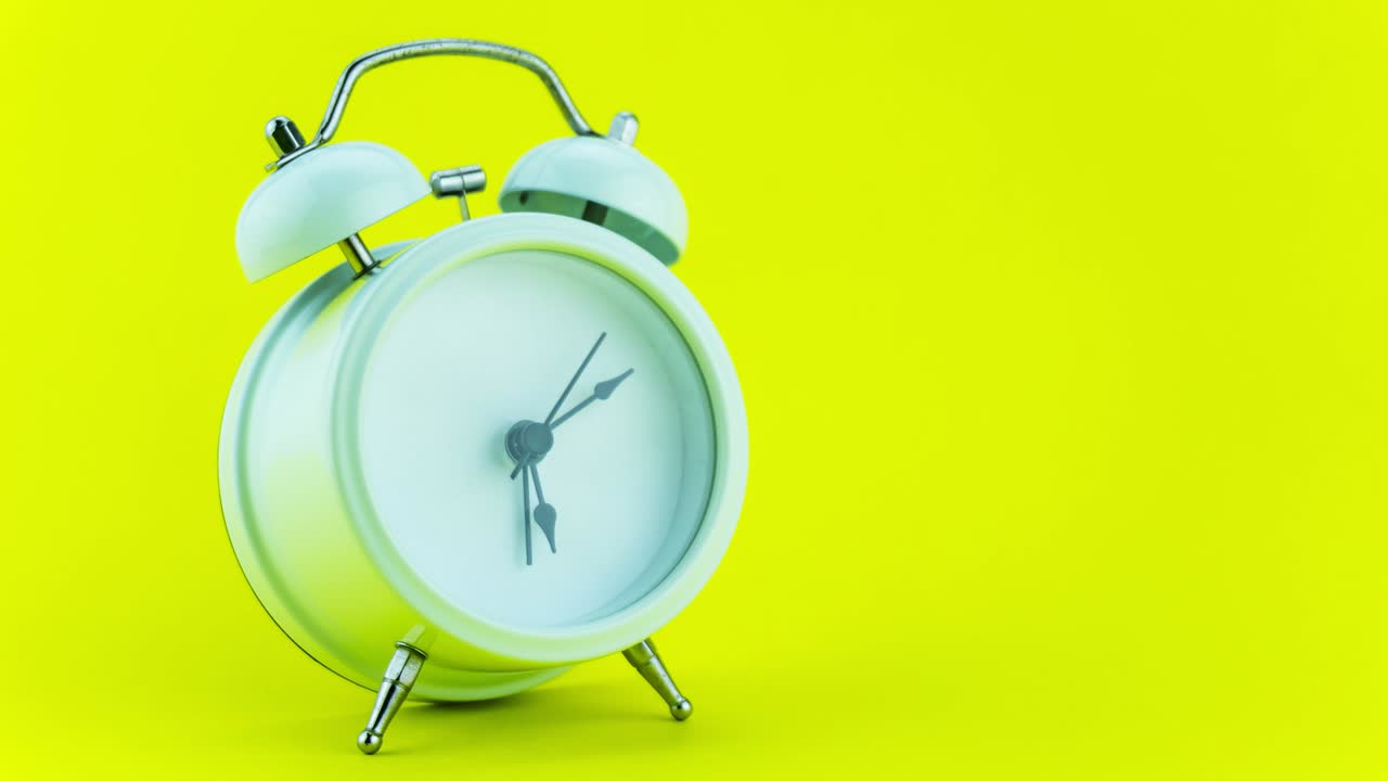 4k 스 모션 애니메이션: 아름다운 클래식 아날로그 알람 시계, 노란색 벽 배경에서 빠르게 움직이는 색 알람시계, 타임 스 얼굴, 아침 시간에  모션, 미니멀 알람시