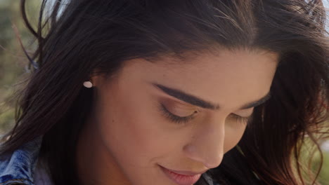 close up portrait of beautiful indian woman enjoying peaceful sunny day relaxing on summer vacation with wind blowing hair