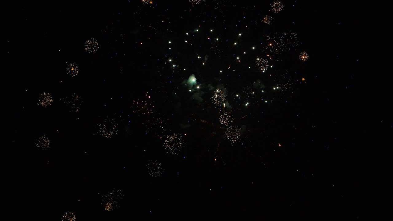 Fireworks in slow motion on black background at night amazing and colorful graphic multiple explosions in a row