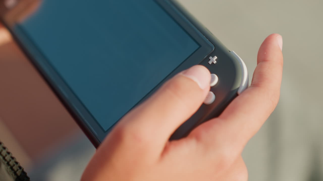 Primo piano delle mani che tengono una console portatile durante un gameplay veloce, pollice che preme pulsanti e grilletti, reazioni rapide delle dita, energia competitiva tesa, attenzione sul touchscreen e sull'input, giocatore giovane.
