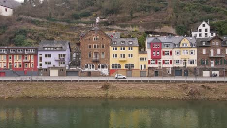 static shot of the river banks with beautiful old houses with their typical facades in the incredibly beautiful german town of cochem stretching over the river moselle