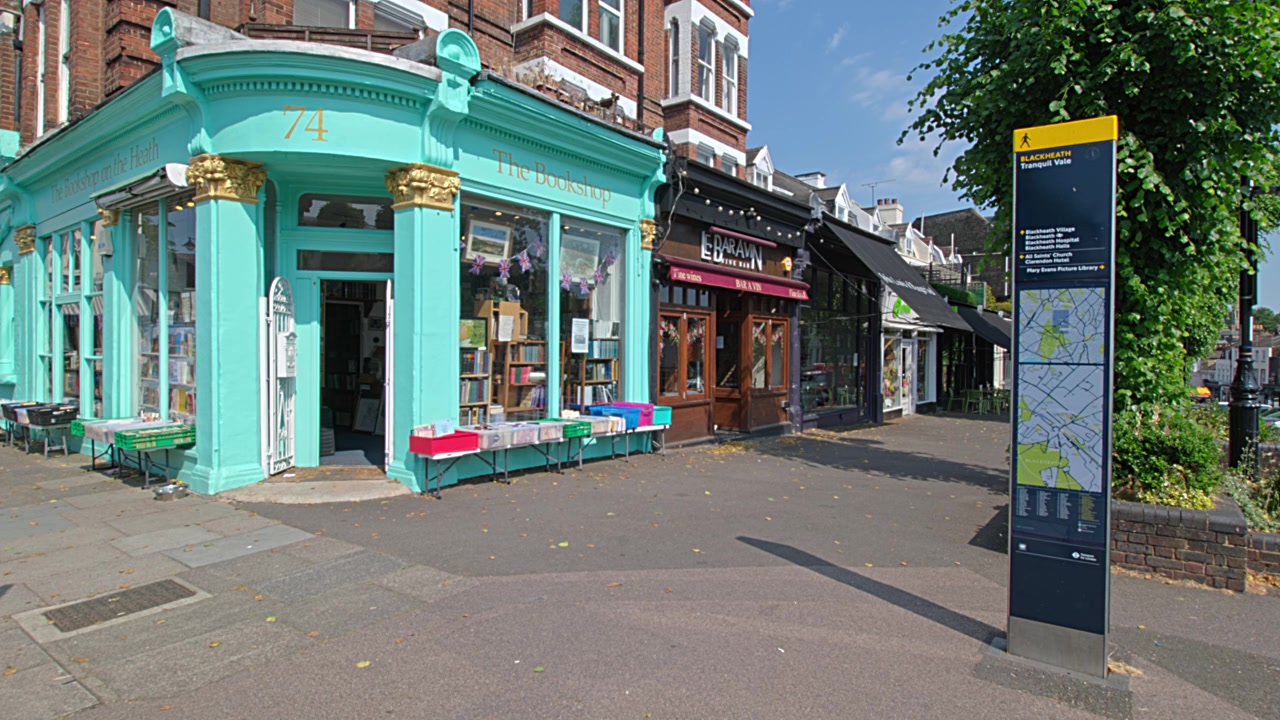 Hjørneboghandel i Blackheath Village Centre, med turistskilt og kort.