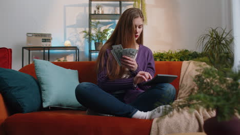 rich young woman counting money cash and use calculator calculate domestic income earnings at home