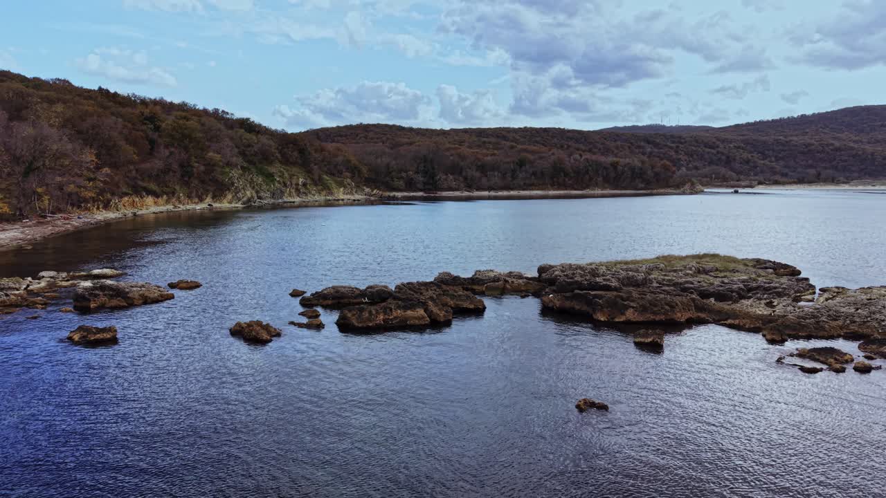 Scenic aerial view of tranquil water and rocky shoreline during daytime
