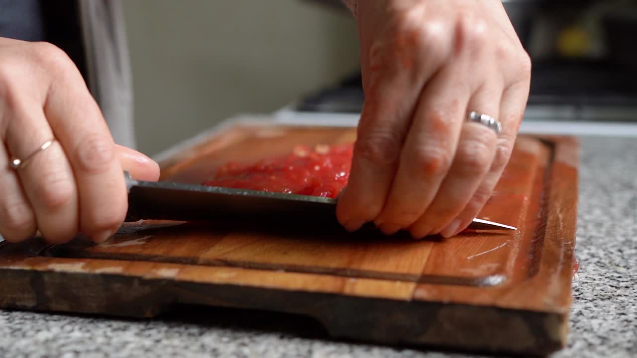 Chef's Hand Chopping Quickly Red Tomatoes Using Knife on Wooden Board