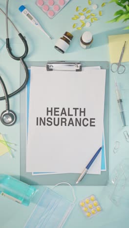 vertical video of health insurance written on medical paper