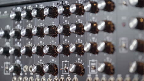 streak of light on knobs of an audio mixing console in a recording studio