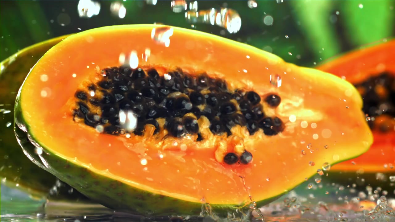 Schizzi d'acqua su un frutto di papaya fresco e arancione