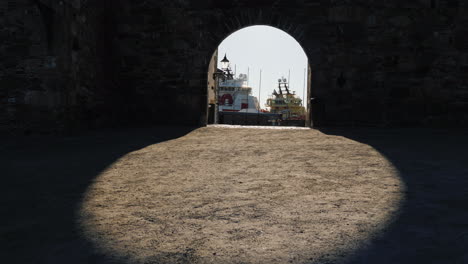 view of the sea port through the arch of the ancient fortress wall the shadow creates a beautiful ov