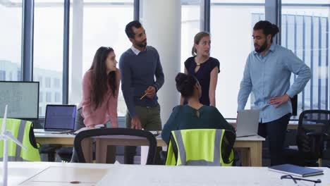 grupo diverso de colegas arquitectos masculinos y femeninos se reunieron alrededor de una mesa y discutiendo