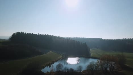 Luftaufstieg-über-Wald-Und-See-In-Der-Morgensonne