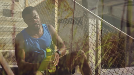 animación de la hierba sobre el ejercicio hombre afroamericano tomando un descanso de agua sentado en el sol