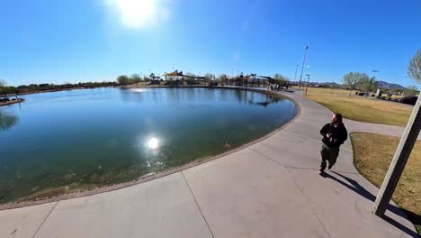 static red haired male walking around the lake in mansel crater park in queen creek arizona.
