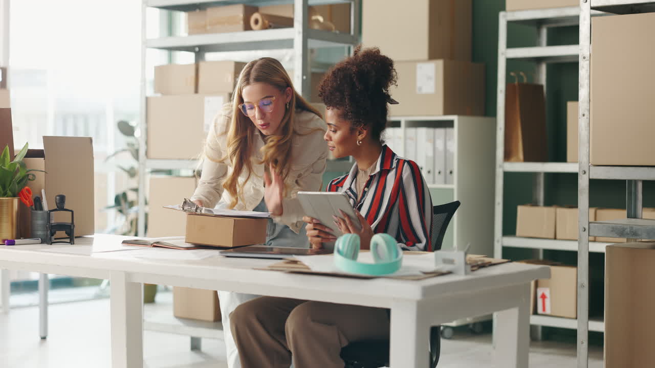 Women working together in a small business office with boxes and a tablet
