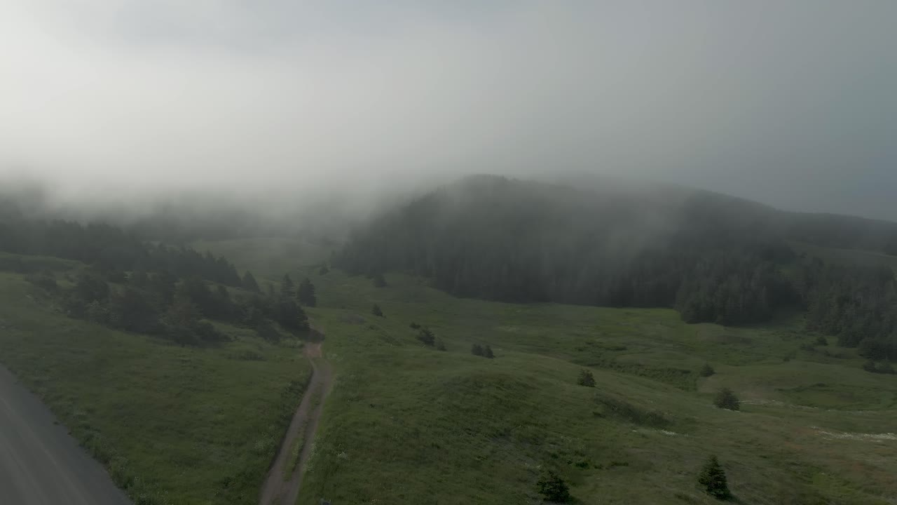 Aerial parallax flight in clouds above green Quebec Magdalen islands