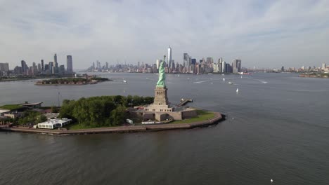 aerial view passing the statue of liberty, towards the lower manhattan skyline, in nyc, usa