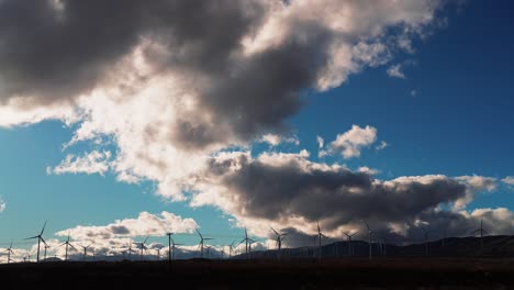 el viento sopla a través de un parque eólico en el desierto de mojave generando energía limpia en un día nublado - vista panorámica estática de gran angular