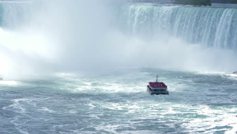 Tourist-cruise-boat-approaching-the-Niagara-Falls-waterfalls,-steady