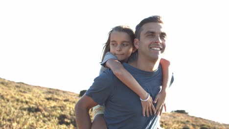 happy father piggybacking daughter kid