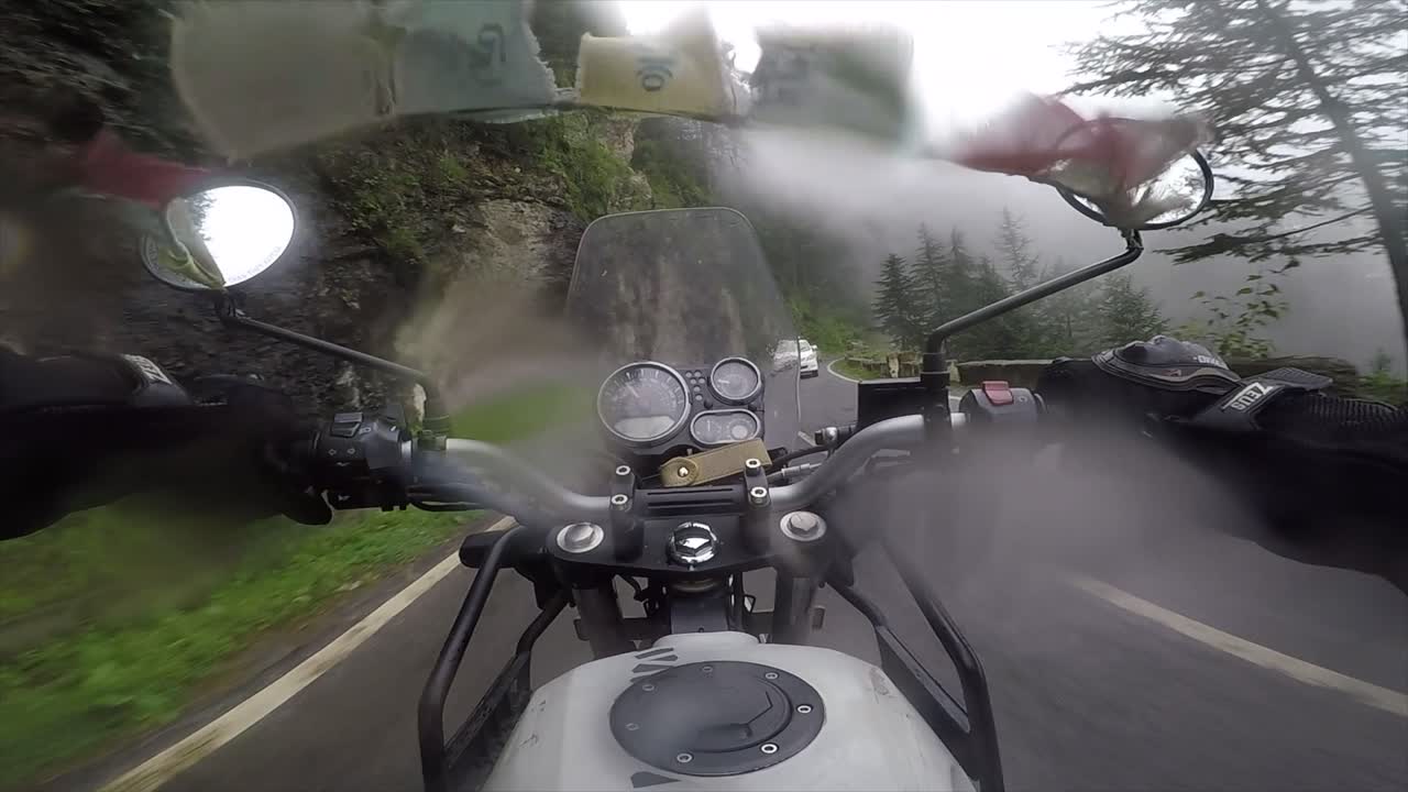 Driving at speed around corners in the mountain road areas with water drops on the lens.