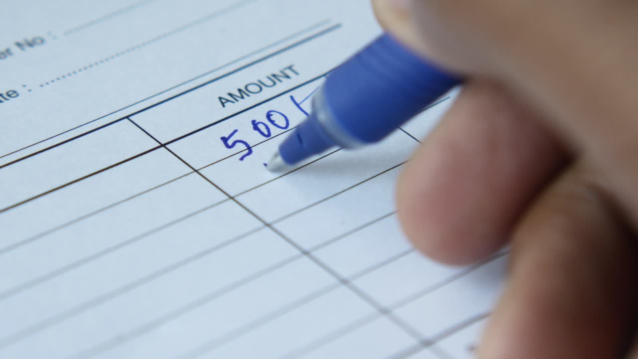 una mano escribiendo números en un formulario