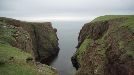 Windy-day-in-remote-Shetland-Isles-showing-coastal-erosion-and-nesting-birds-on-cliff-face