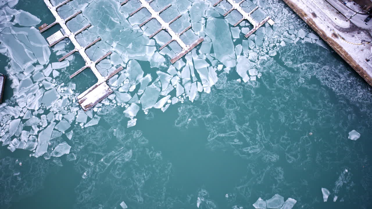 Tomada aérea de drone de inverno de marina congelada e águas geladas do porto no Lago Michigan, perto do centro de Chicago Loop