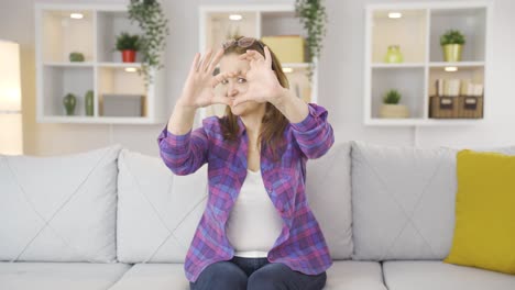 woman making heart symbol for camera.