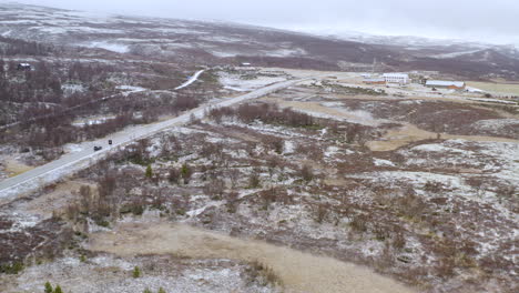 snowfall at dovre with vehicle traveling along fields with trees in wintertime in norway