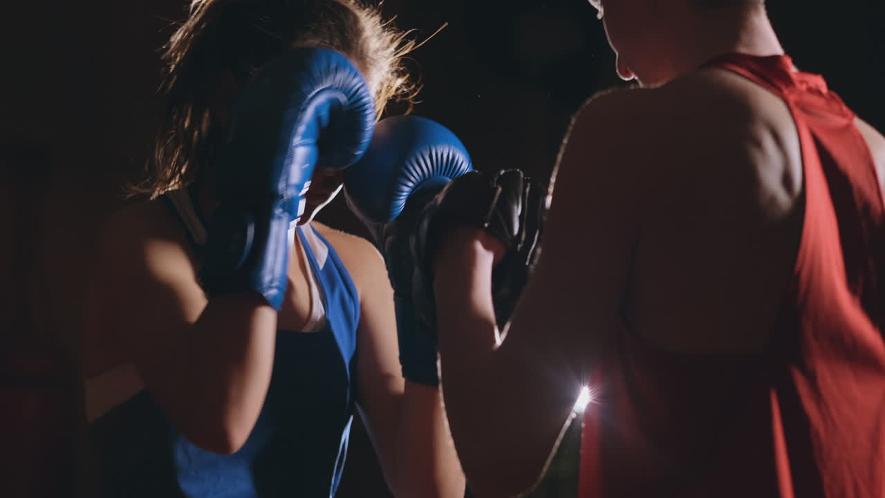 mujer adulta joven haciendo entrenamiento de kickboxing con su entrenador.