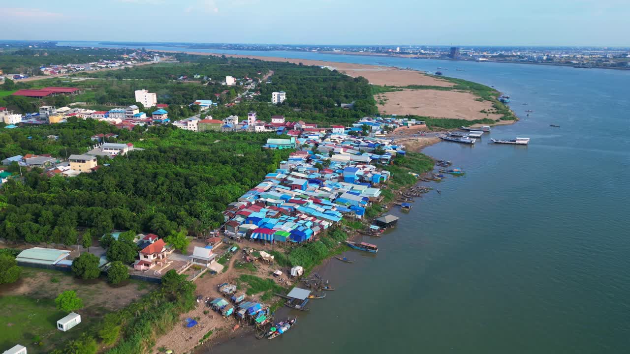 fishing village with colorful shacks along the Mekong river in Cambodia, a developing country in Southeast Asia. Lovely aerial view flight drone shot footage from above