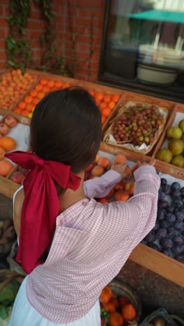 woman shopping for fruit at a market