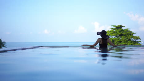 Mujer-De-Pie-En-La-Piscina-Disfrutando-De-La-Vista-Al-Mar