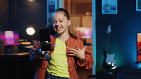 happy child taking part in viral dance craze filming video with smartphone attached to selfie stick