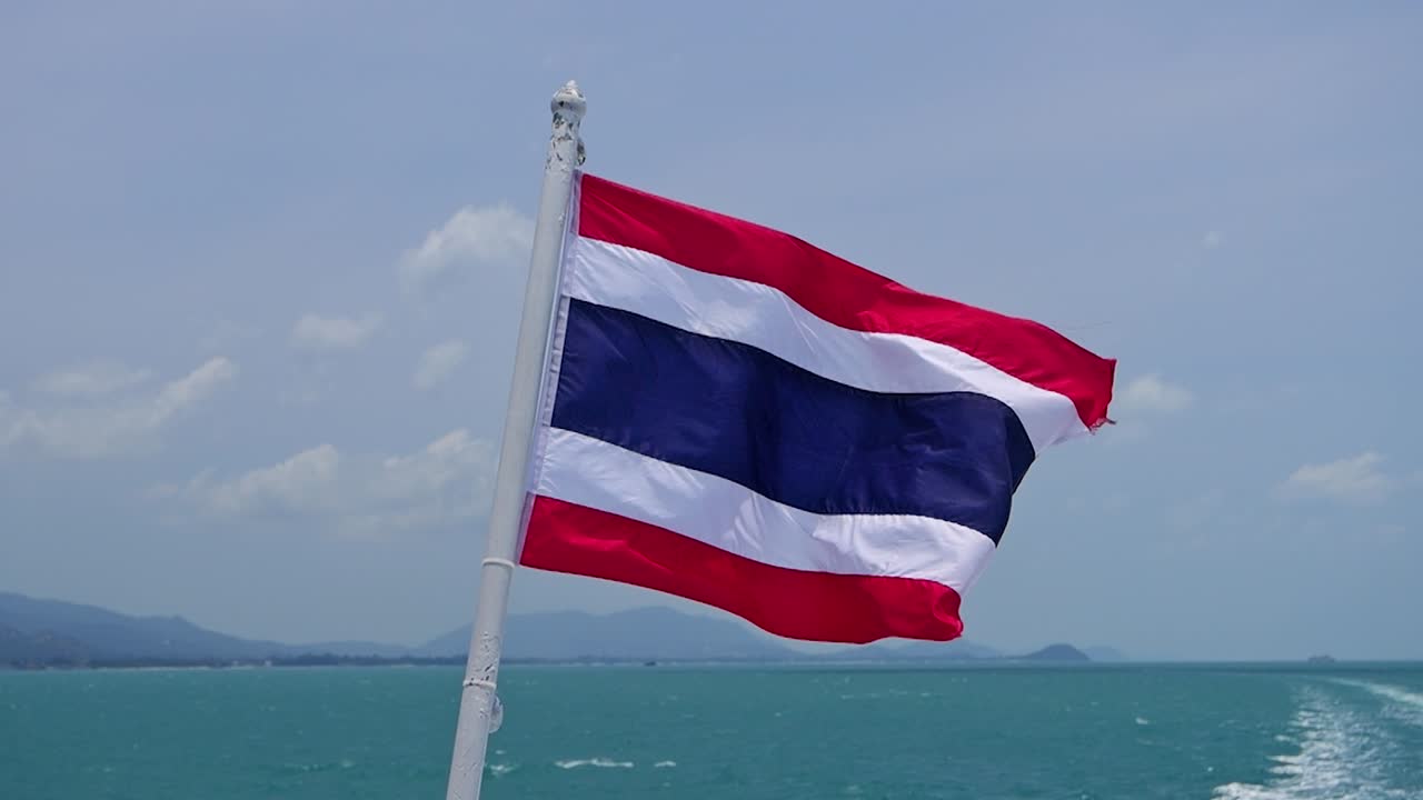 супер замедленный вид тайского флага, размахивающегося с задней части лодки на открытом океане